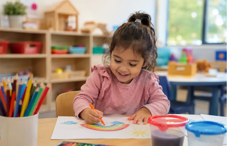 Preschool child drawing and learning in a classroom